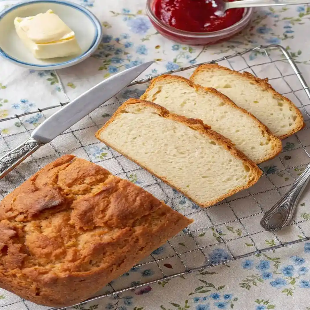 Top view of sliced gluten-free bread with butter and jam.