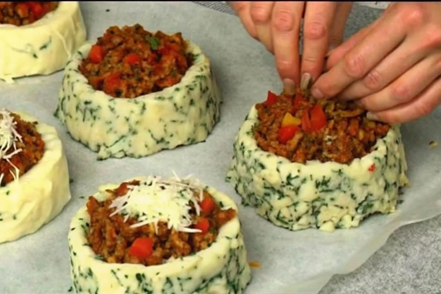 Stuffed Mashed Potato Nests Recipe 2 A close-up shot of a golden-brown chicken pot pie in a white ceramic dish, with a section scooped out to show a creamy filling of chicken, carrots, and peas.