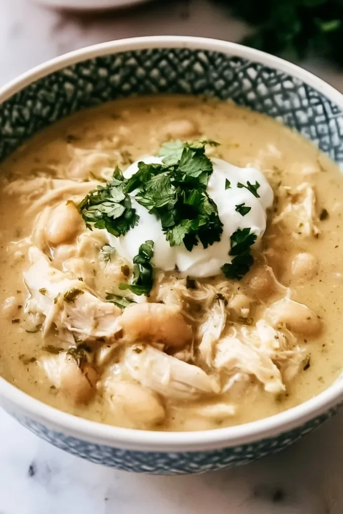 Bowl of creamy white chicken chili topped with cilantro and lime.