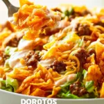 Delicious taco salad topped with Doritos and cheese in a colorful bowl